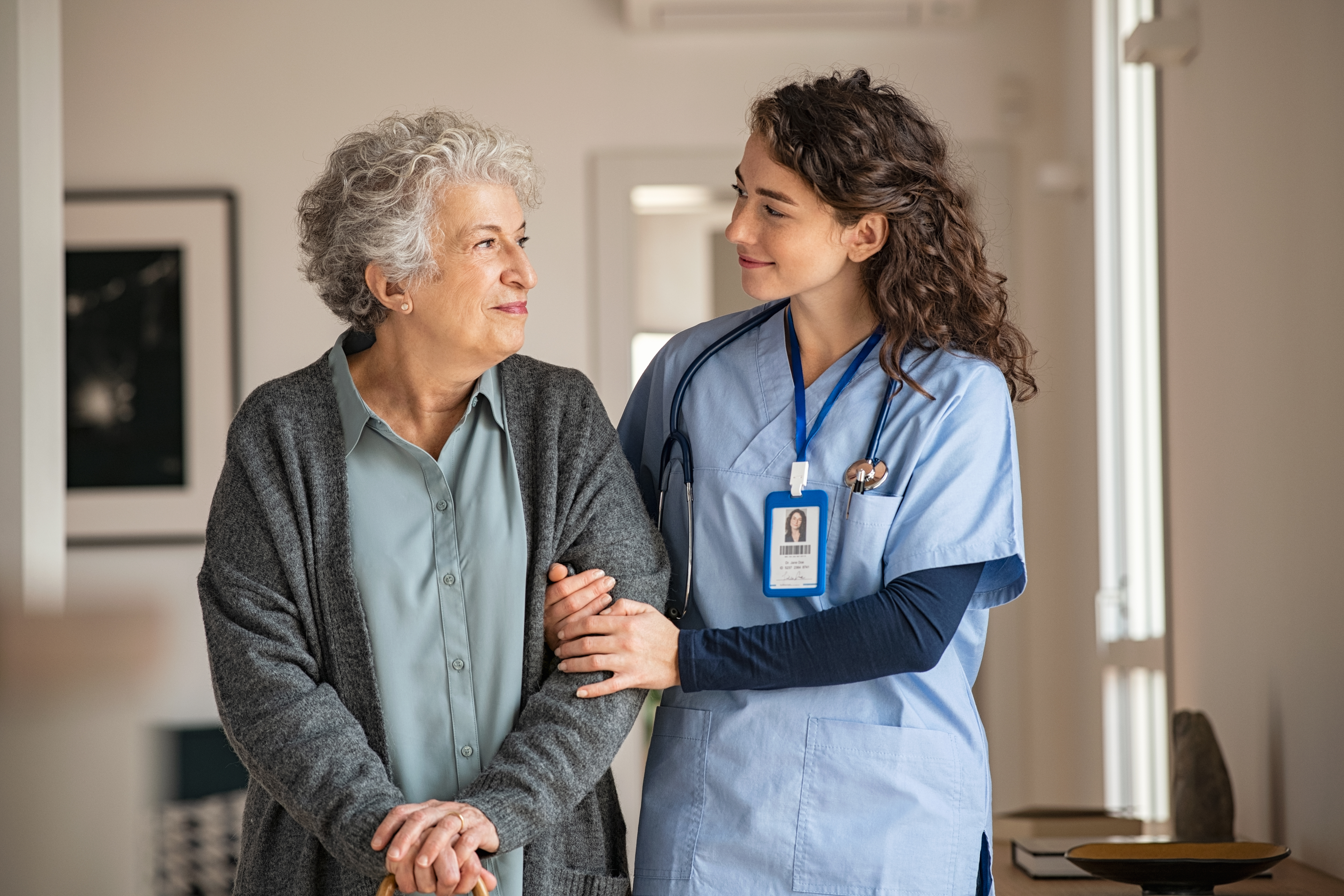 A female nurse is helping an elderly woman walk. 