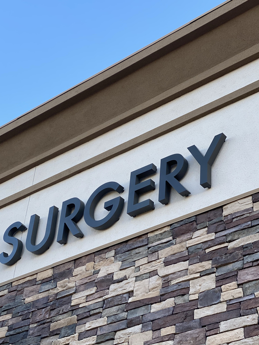 A surgery sign on aside of a building.