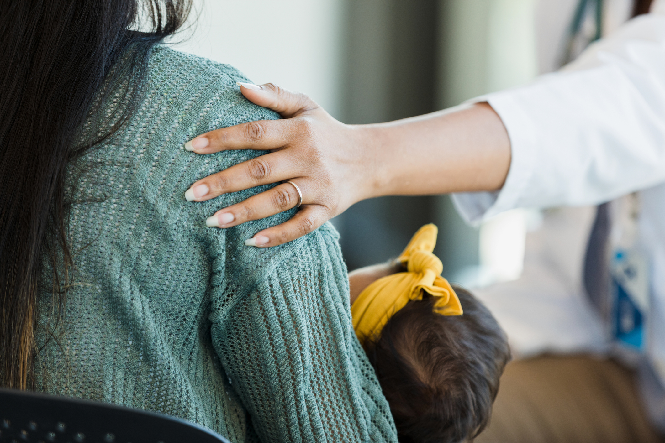 A person's hand on another individual's shoulder.