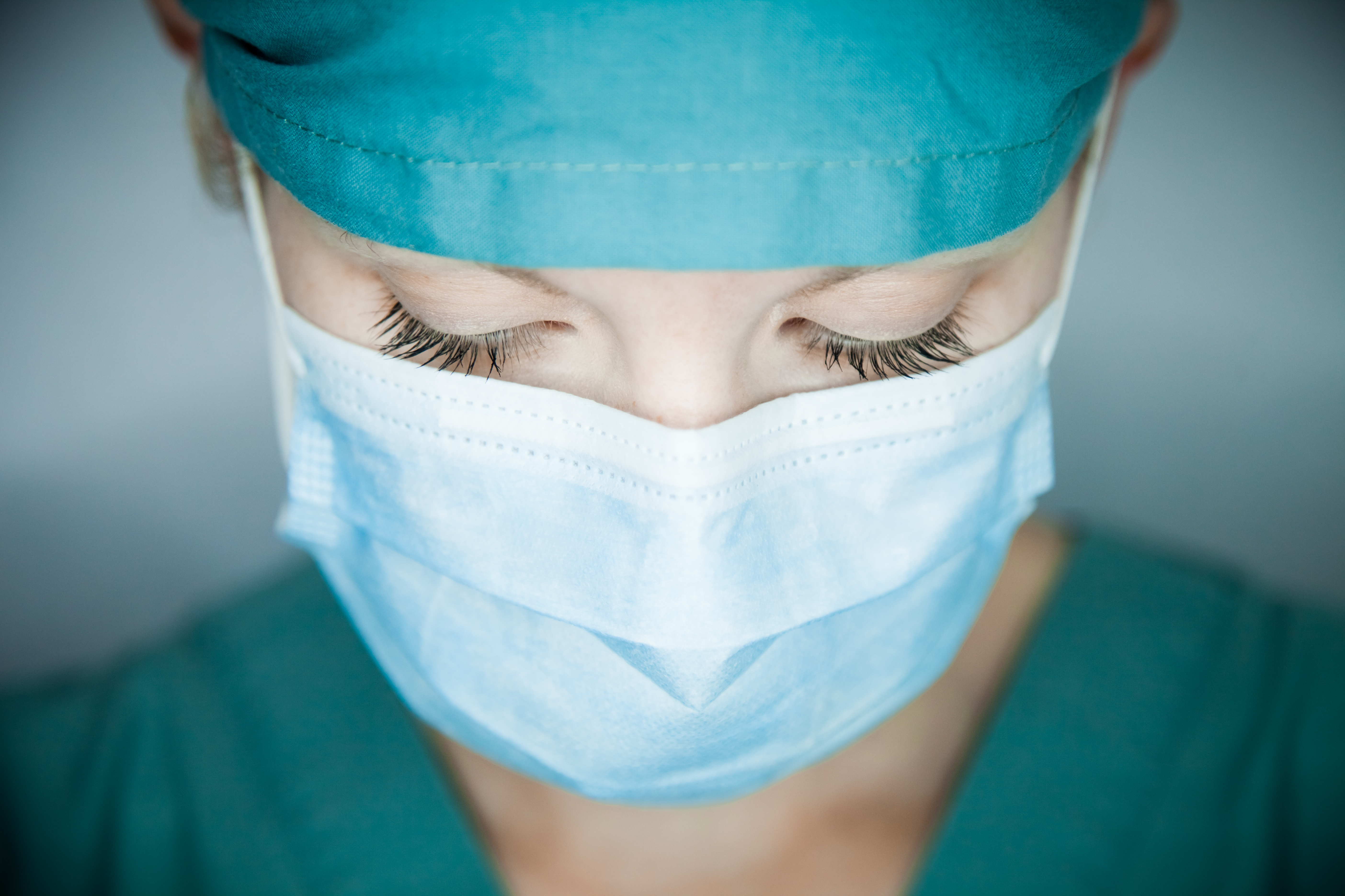 Close up of  female with mask on and scrubs.