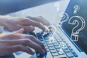 Laptop open with a person hands typing with floating questions marks.