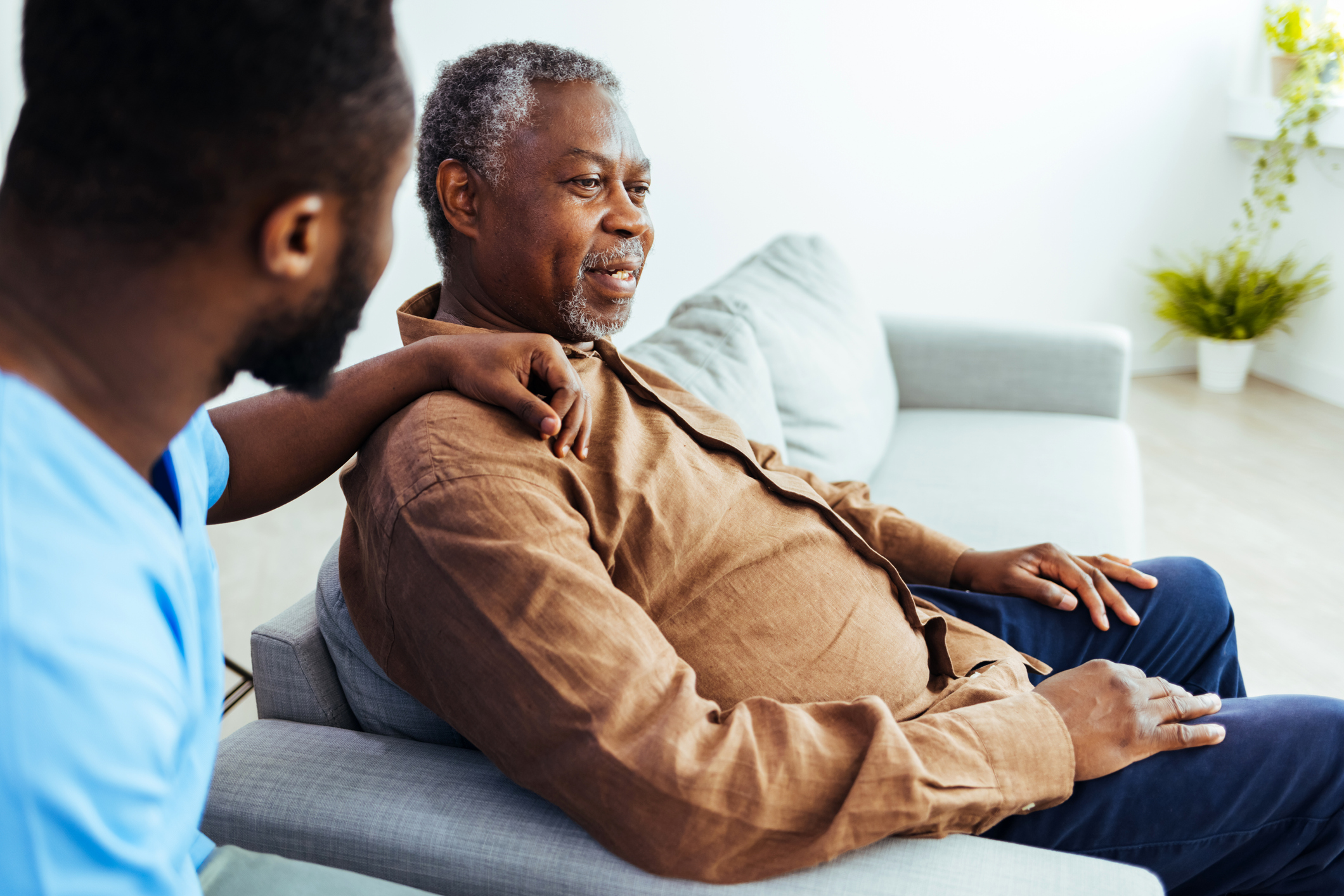 An elderly patient is comforted by a nurse at an assisted living facility.