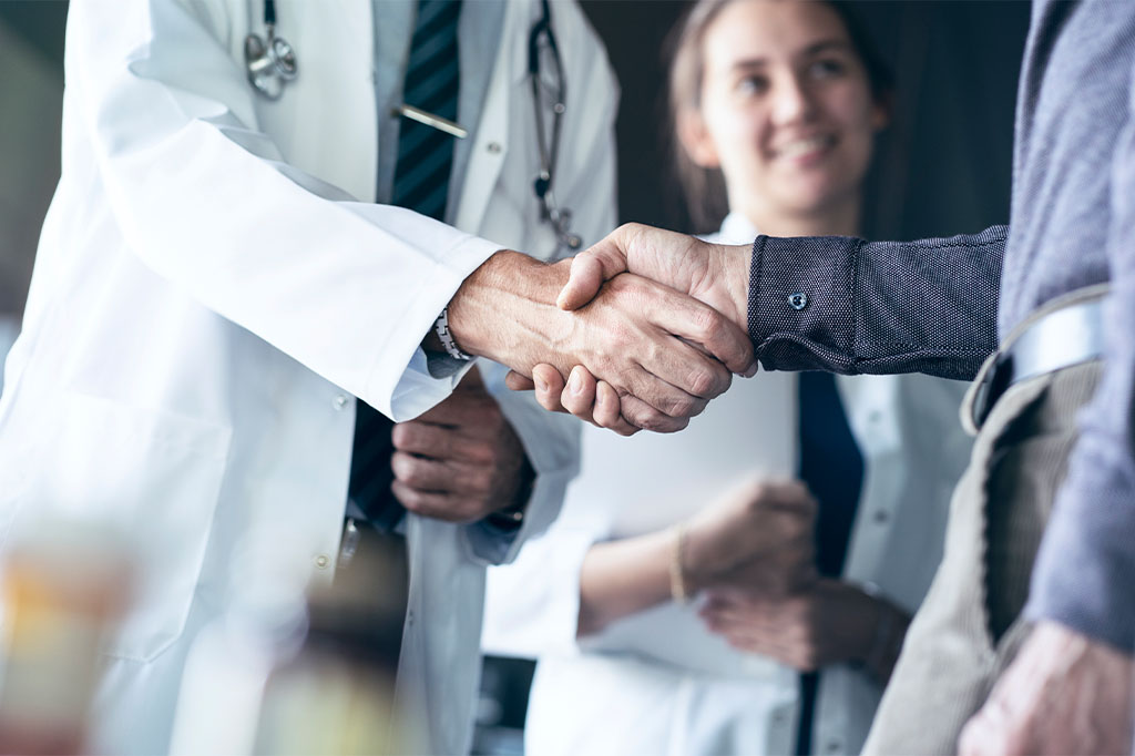 A doctor shakes hands with an administrator