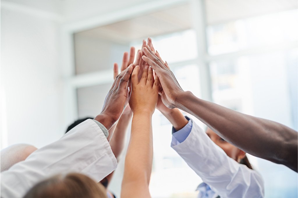 A group of medical professionals perform a group high five