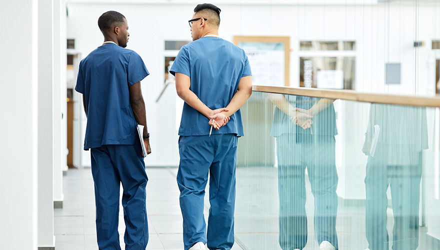 Two nurses with their backs towards the camera.