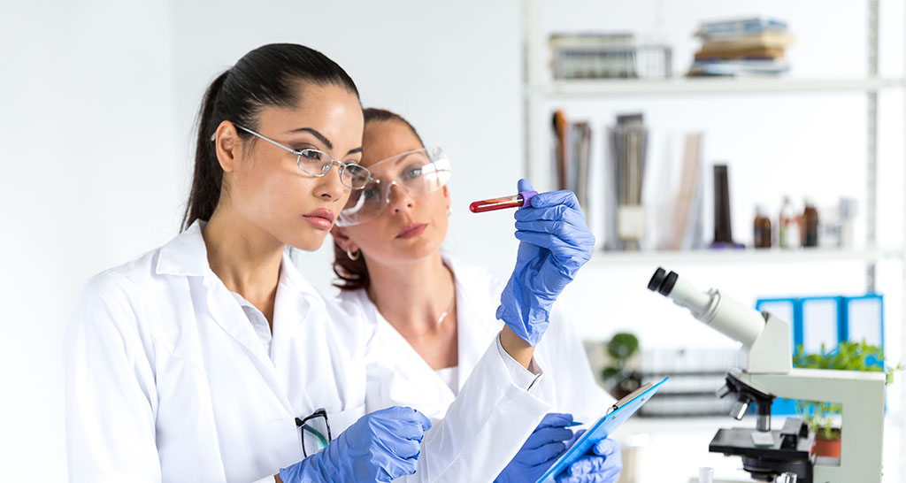 Two female laboratory technicians examining a blood sample.