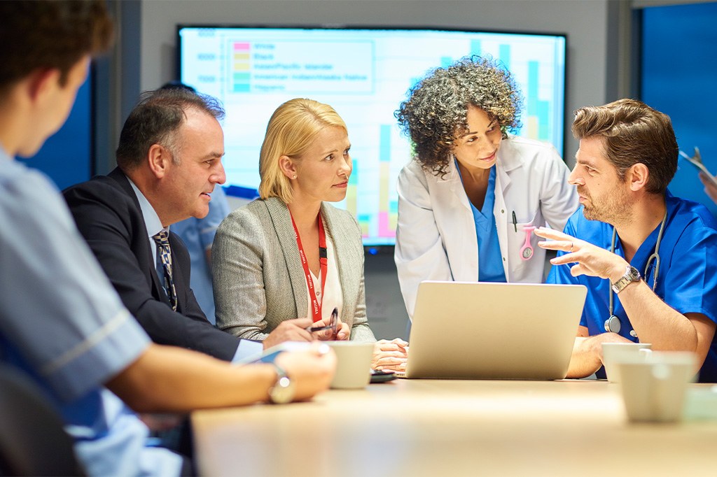 A team of doctors has a meeting with administrators in a conference room