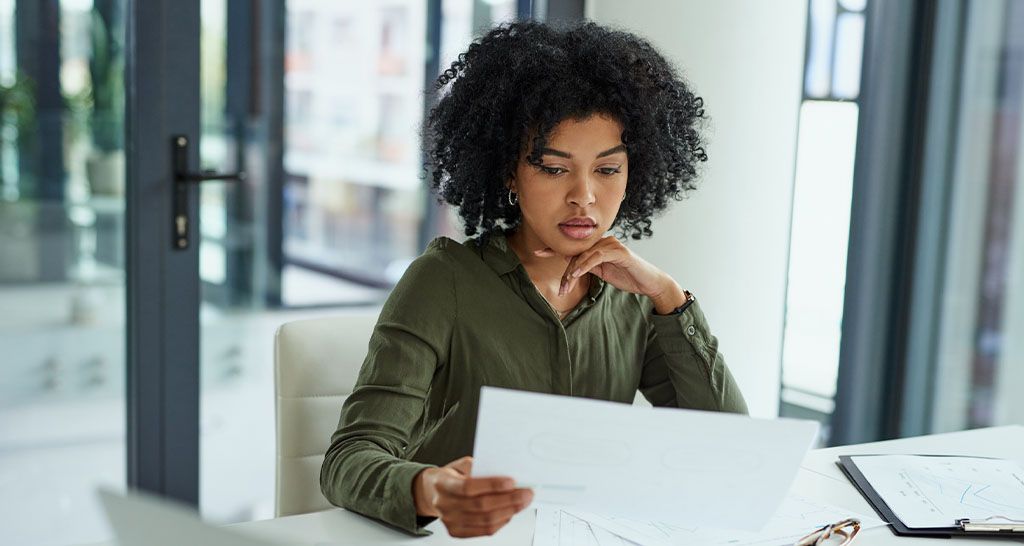 A female business professional reviews notes at her desk