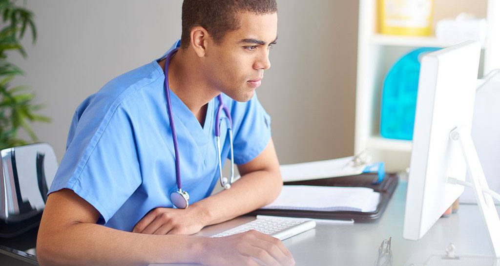 A doctor uses a desktop computer