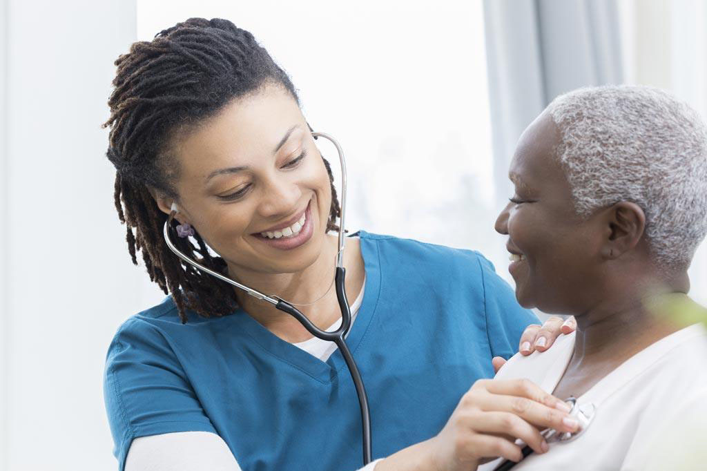 A nurse uses a stethoscope with a patient