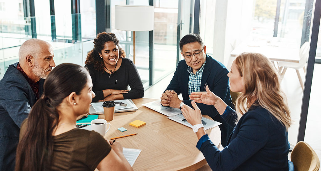 A group of business professionals have a meeting in a conference room