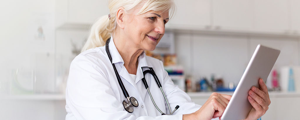 Female doctor using digital tablet in her office.